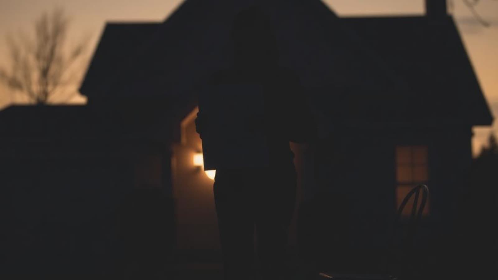 Silhouette di persona con documenti mutuo davanti a una casa al tramonto — morte cointestatario mutuo