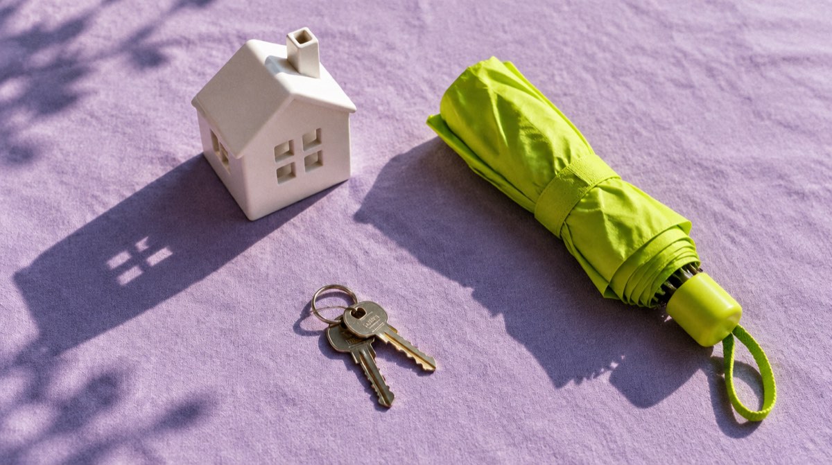 Scudo verde con silhouette di famiglia e casa su sfondo beige — polizza vita sul mutuo